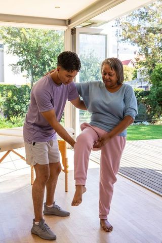 Elderly patient rehabilitating with physiotherapist for balance training