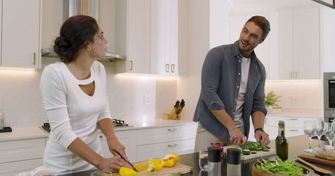 Couple bonding over meal preparation in modern kitchen