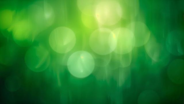 Glowing Green Bokeh Backdrop with Luminous Orbs, Soft Vertical Streaks, Emerald Glow