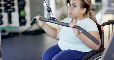 Woman in Wheelchair Exercising for Rehabilitation in Gym