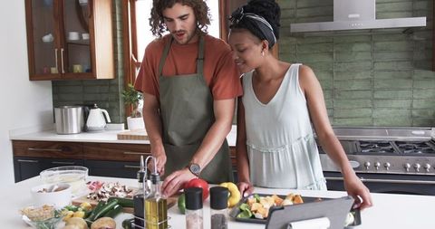Couple cooking together in modern kitchen preparation