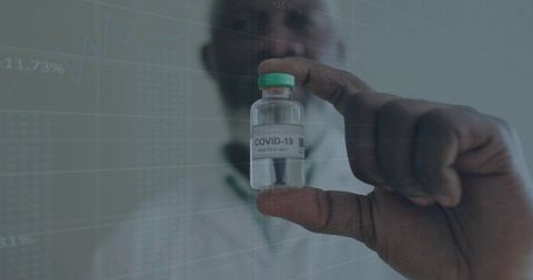 Holding COVID-19 vaccine vial with data overlay for research and healthcare analytics