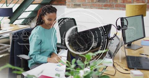 Woman designing charts with coding on screens in modern open-plan workspace