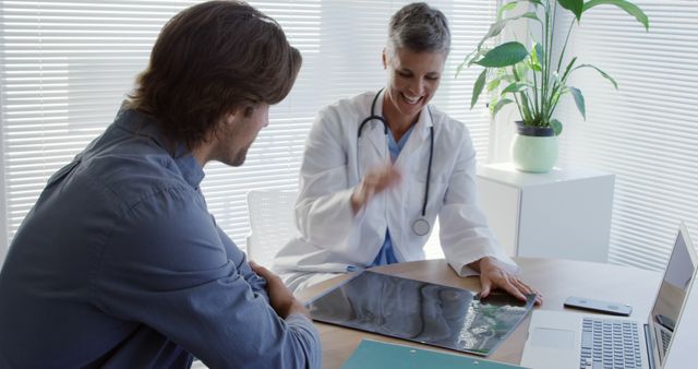 Doctor Discussing X-Ray Results with Male Patient in Office - Download Free Stock Images Pikwizard.com