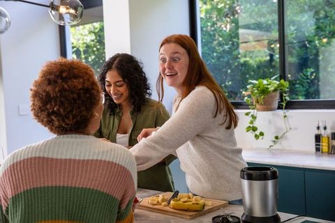 Diverse Friends Preparing Fruit Together in Contemporary Kitchen