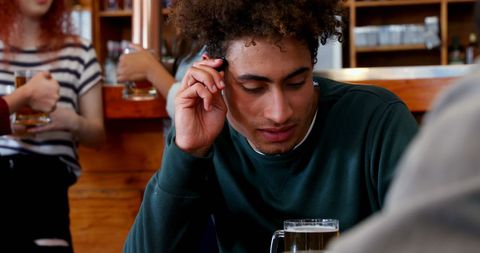 Young Man Enjoying Conversation in Bar with Friends - Download Free Stock Images Pikwizard.com