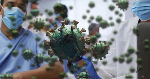 Healthcare workers holding virus model in clinical lab demonstrating biosafety practices