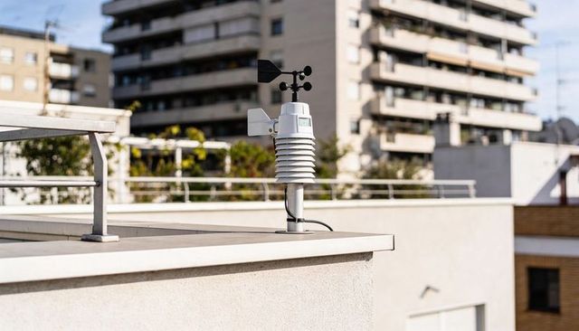 Rooftop weather station measuring wind and temperature on urban terrace