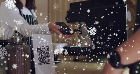 Barista Holding Card Reader While Customer Tapping Phone for Contactless Winter Payment
