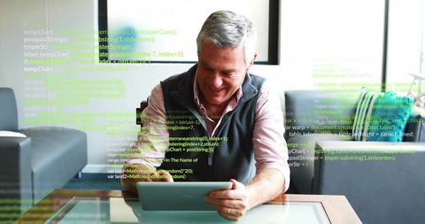 Senior man using tablet in lounge with floating code overlay, enjoying modern connectivity