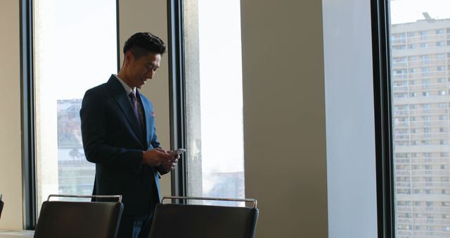 Businessman Using Smartphone in Modern Office with City View - Download Free Stock Images Pikwizard.com