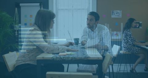 Multiracial Team Collaborating in Office with Financial Graph Overlay