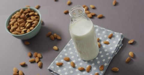 Healthy plant-based almond milk with almonds on table
