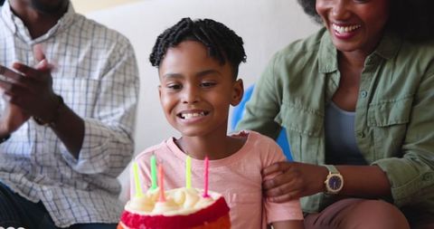 Happy Family Celebrating Young Boy's Birthday With Cake