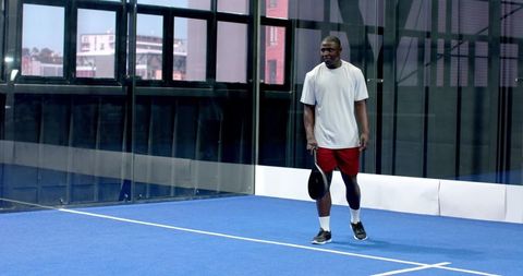 Urban Padel Player on Blue Court Focusing on the Game