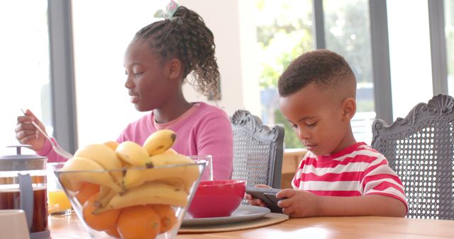 Siblings Having Breakfast, Brother Playing with Mobile Phone - Download Free Stock Images Pikwizard.com