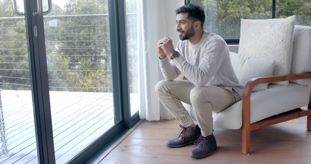 Smiling Man Relaxing and Daydreaming by Modern Window - Download Free Stock Images Pikwizard.com