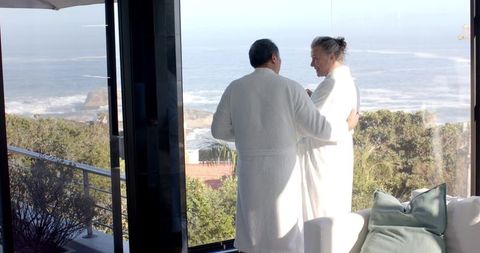 Senior Couple Embracing Scenic Ocean View in Luxury Resort