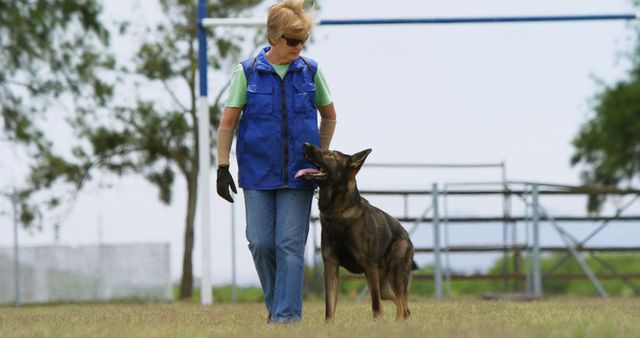 Elderly Woman Walking German Shepherd on Outdoor Field - Download Free Stock Images Pikwizard.com