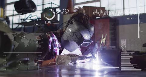 Female welder welding at workbench with helmet and gloves, sparks in industrial workshop