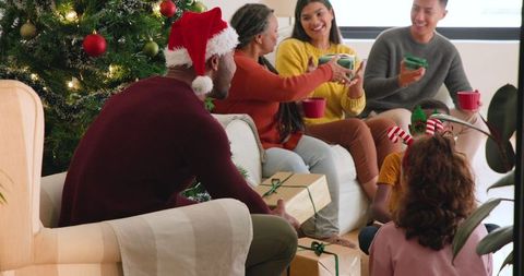 Family Joyfully Exchanging Gifts Near Christmas Tree During Holiday Celebration