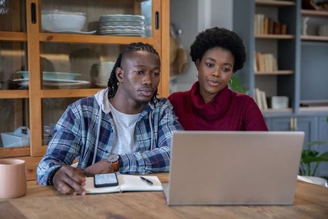 Couple Collaborating on Laptop Together at Home Kitchen