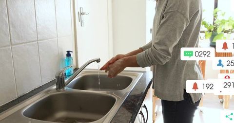 Woman Washing Hands at Kitchen Sink with Notifications Overlay