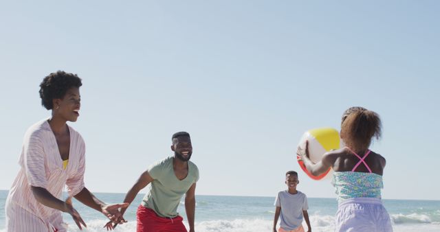 African American Family Playing with Beach Ball at Sunny Coastline - Download Free Stock Images Pikwizard.com