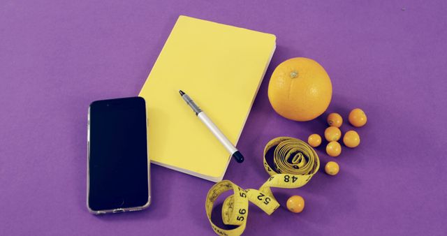 Healthy Lifestyle Preparation with Notebook, Orange, Phone and Tape Measure on Purple Background - Download Free Stock Images Pikwizard.com