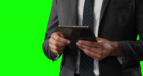 Businessman Using Tablet Relaxed Agains Green Screen
