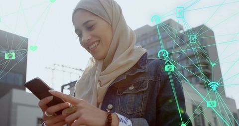 Woman in Hijab Interacting with Data on Smartphone Outdoors
