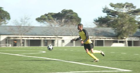 Dynamic soccer player dribbling ball on field