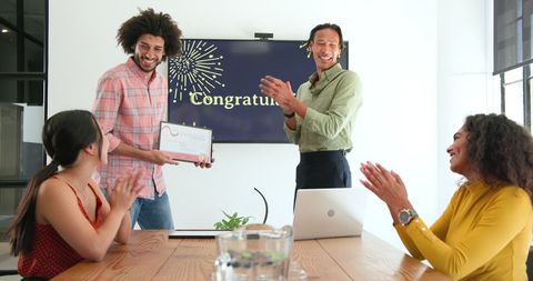 Colleagues celebrating achievement in modern office meeting