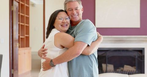 Happy Senior Couple Embracing in Cozy Living Room Setting
