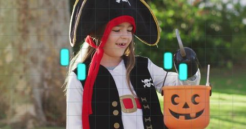 Girl holding pumpkin bucket and toy pirate hook while wearing tricorn hat and vest