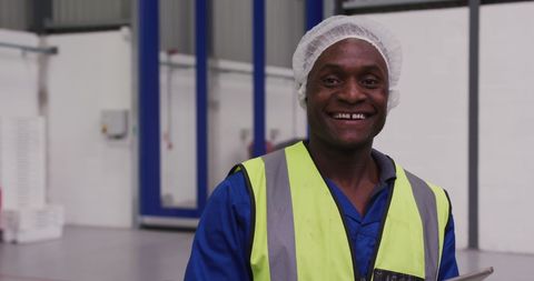 Happy factory worker in high visibility clothing smiling