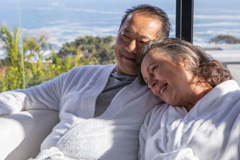 Senior Couple in Bathrobes Relaxing by Scenic Window