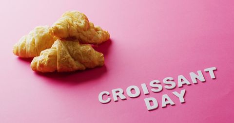 Celebrating croissant day with fresh croissants on pink