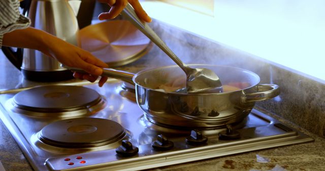 Person Cooking Pasta on Modern Stove in Bright Kitchen - Download Free Stock Images Pikwizard.com