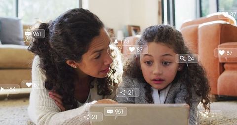 Mother and daughter bonding over tablet with social media icons