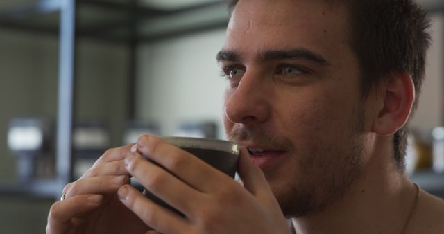 Young Man Enjoying a Hot Beverage in a Modern Cafe - Download Free Stock Images Pikwizard.com