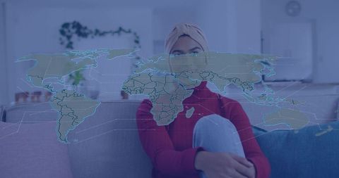 Woman wearing hijab interacting with holographic world map visualizing global data