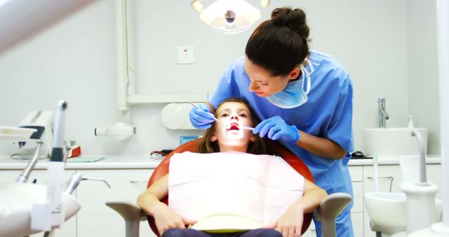 Dentist examining a young patient with tools in dental clinic - Download Free Stock Photos Pikwizard.com