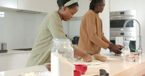 African American Couple Kneading Dough at Modern Kitchen Island with Flour Jar