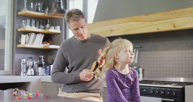 A father tenderly brushes his daughter's hair in a cozy kitchen, implying a close relationship. - Download Free Stock Photos Pikwizard.com