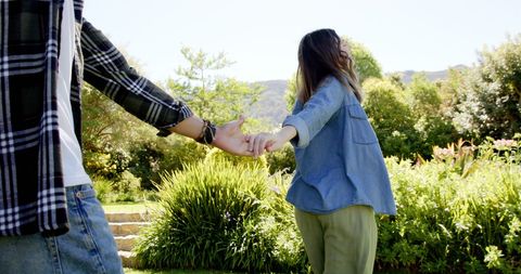 Couple Holding Hands in Bright Sunny Garden