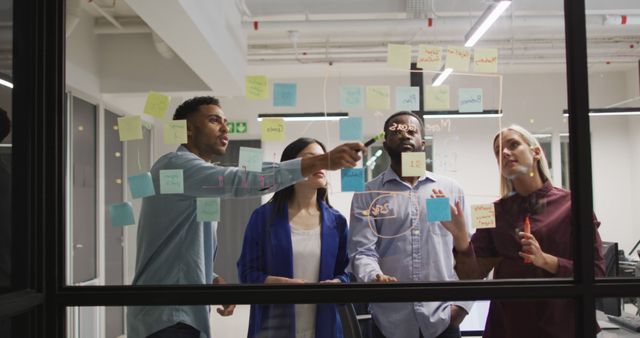 Diverse Team Brainstorming and Using Sticky Notes on Office Glass Wall - Download Free Stock Images Pikwizard.com