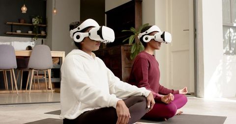 Two Women Exploring Virtual Meditation with VR Headsets in Living Room