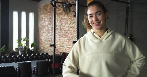 Confident woman smiling in modern industrial gym