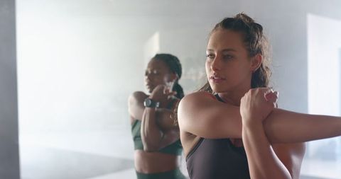 Women Focusing on Fitness in Gym with Stretch Routine
